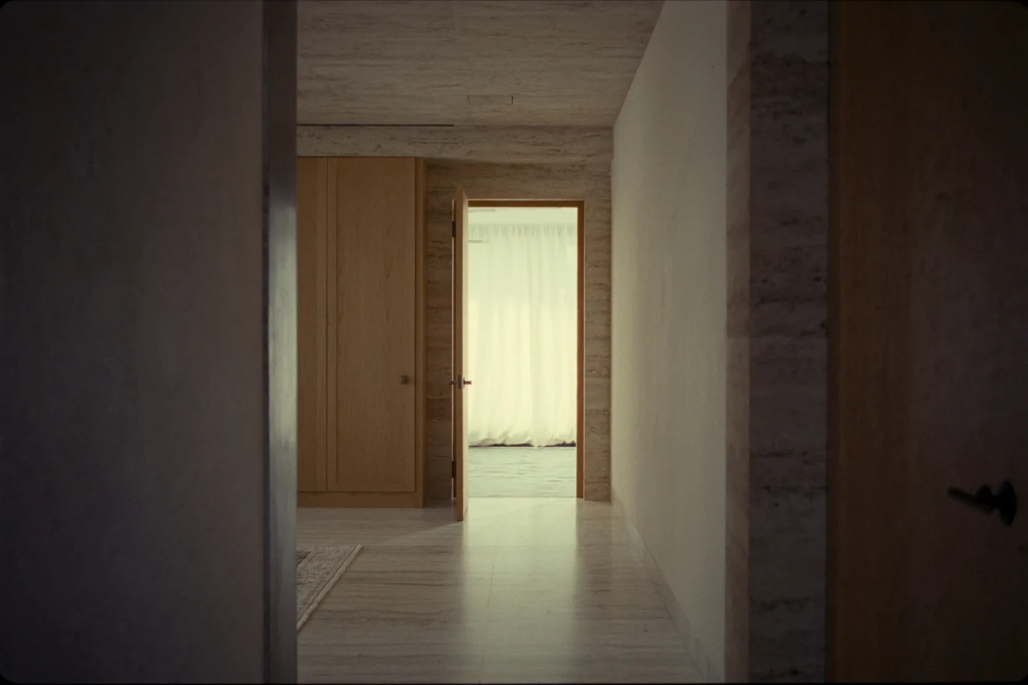 A calm limestone threshold opening onto a light-filled interior room.